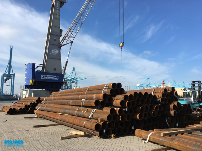 Stalen_buizen_liggen_op_de_kade_in_de_haven_van_Rotterdam-kraan-op-achtergrond